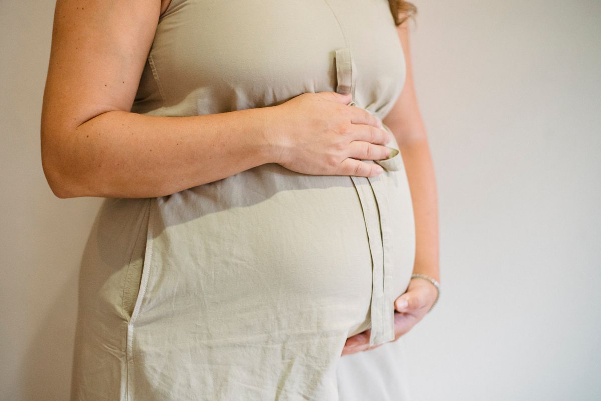 Pregnant woman in third trimester holding her bump