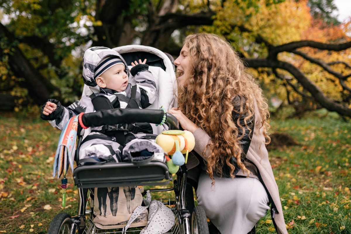 Baby resting in a shaded pram during a calm summer walk in the park