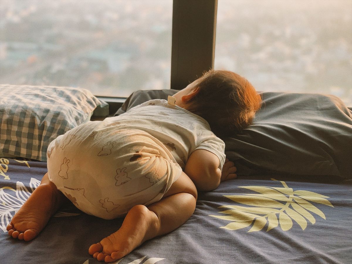 Baby resting indoors near a bright window during spring pollen season