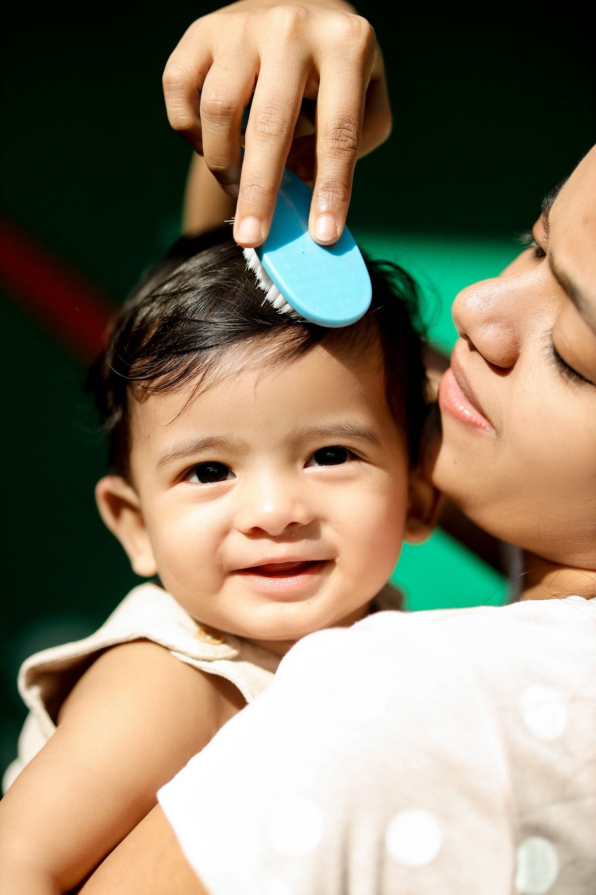 Parent gently brushing baby's hair — cradle cap treatment and care