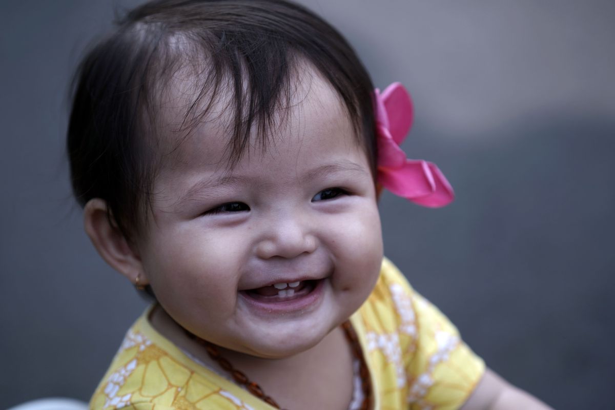 Laughing baby showing her first teeth — guide to baby first teeth and dental care