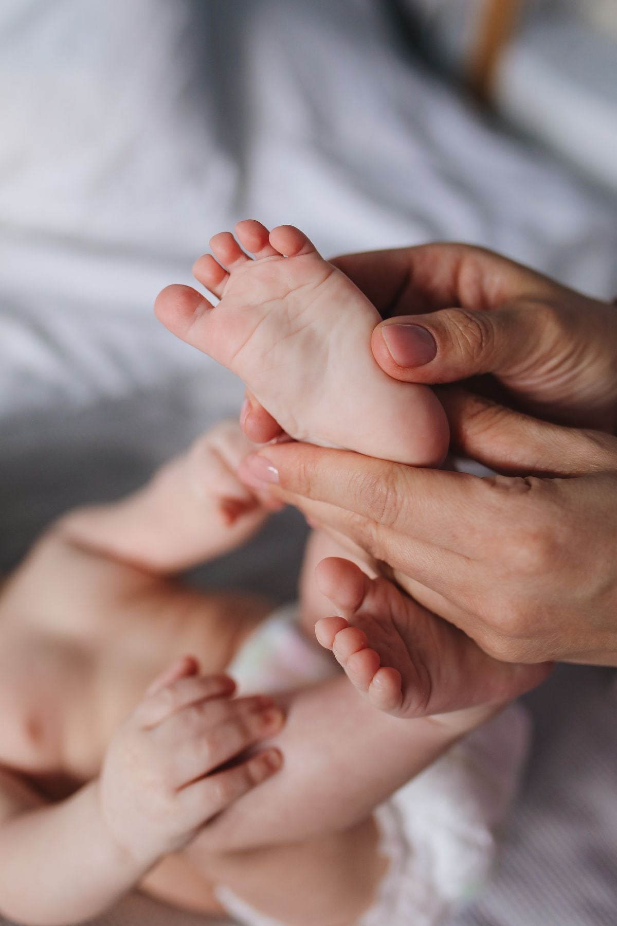 Parent gently comforting and holding newborn baby