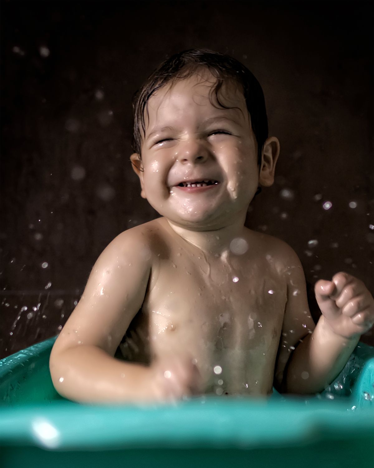 Happy baby at bath time learning new skills