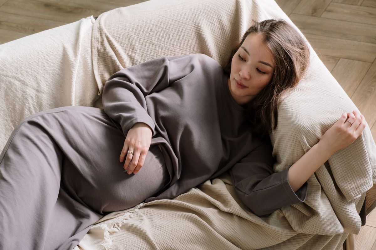 Tired pregnant woman resting on a sofa during early pregnancy