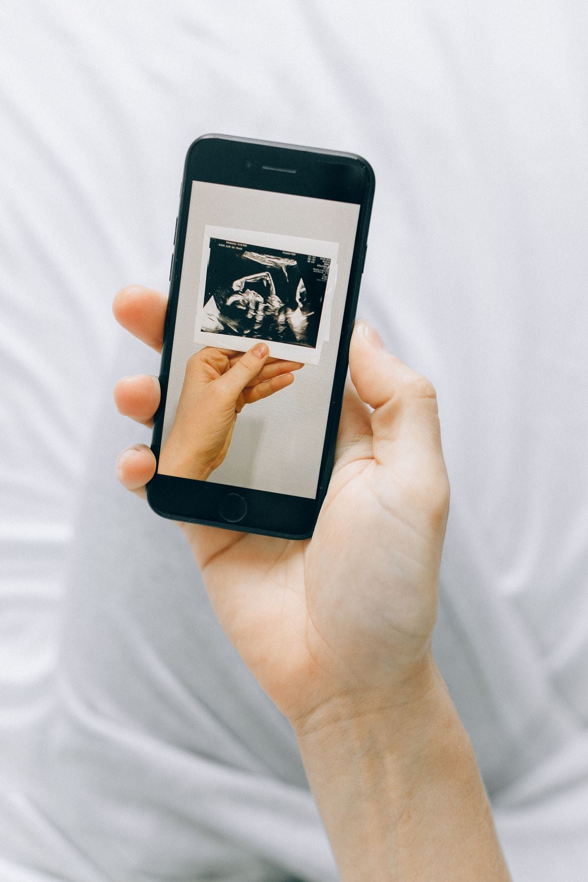 Pregnant woman checking her pregnancy app and notes at home