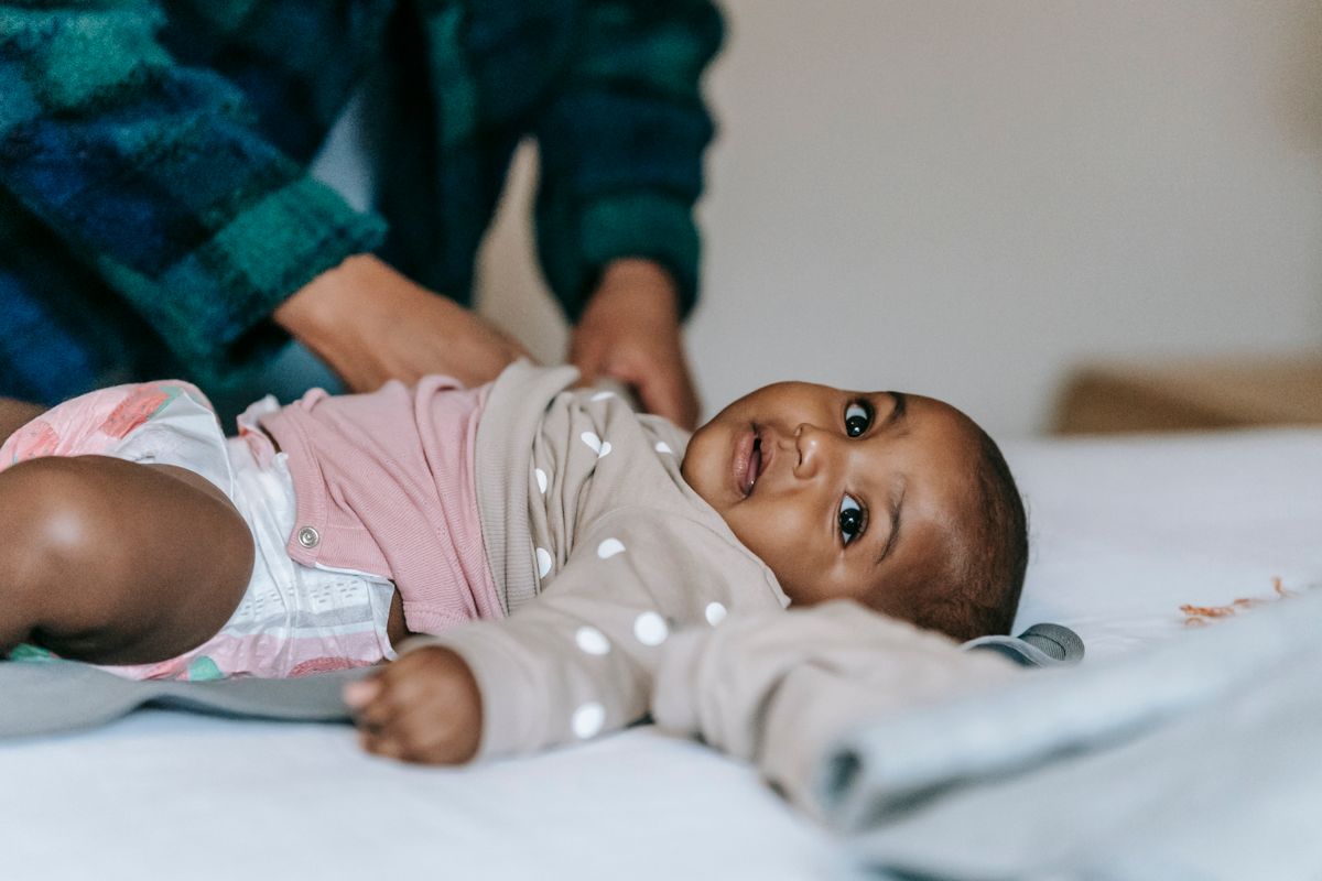 Parent changing a baby's nappy on a changing mat