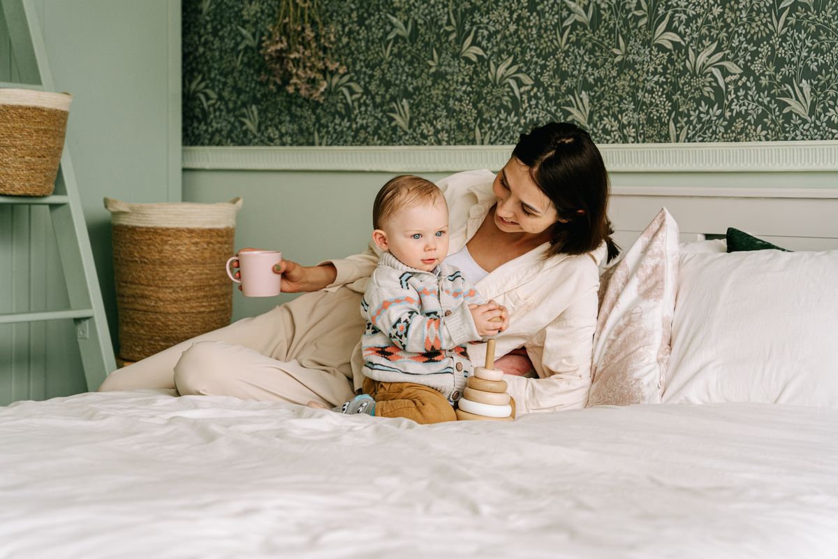 Mother and baby starting the day together on the bed — a calm daily routine