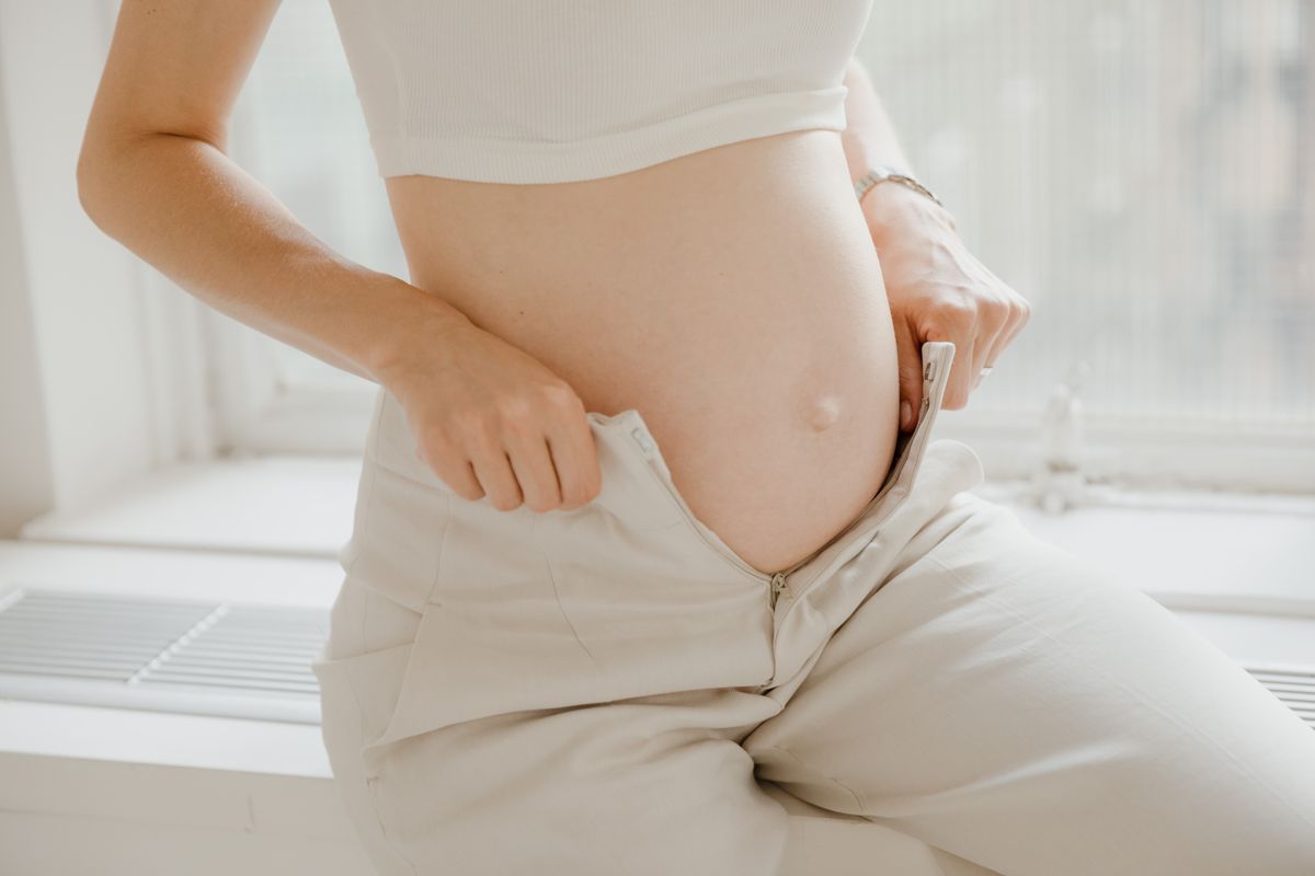 Woman holding a positive pregnancy test at home