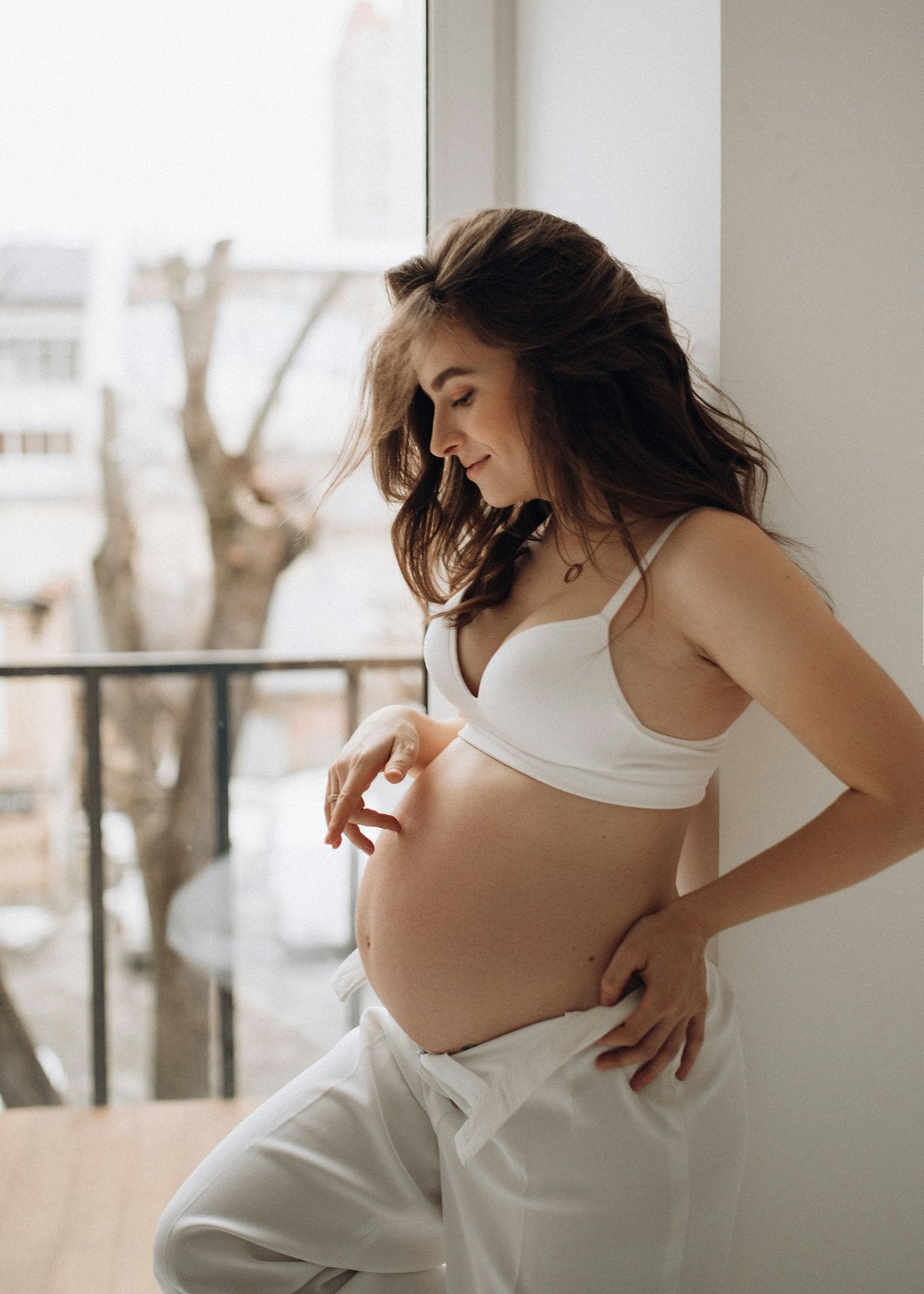 Woman in white dress, early pregnancy