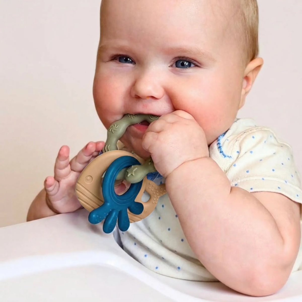 Baby chewing the ring of a blue and green MultiTexture Sea Teether
