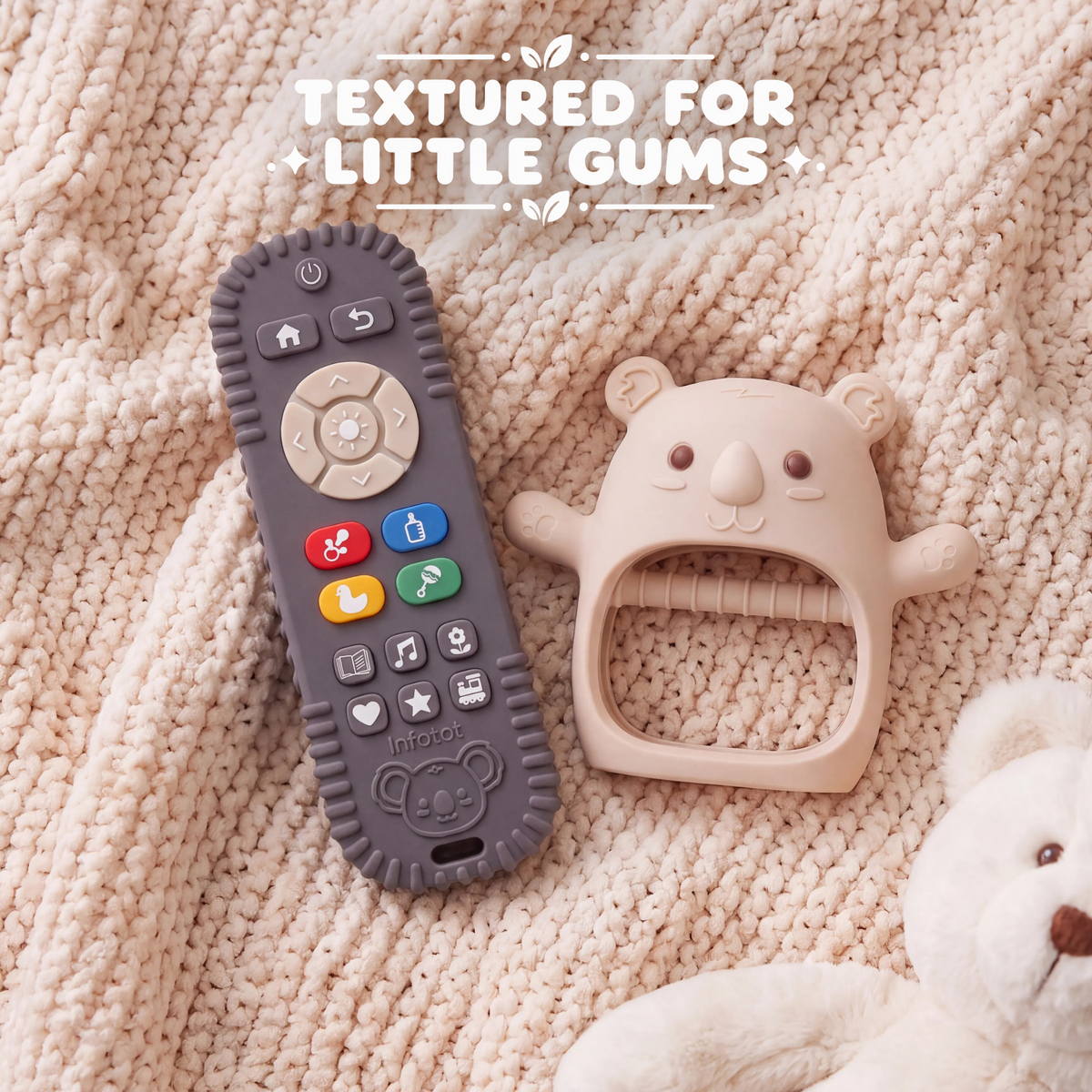 Cream Koda Koala mitten and remote-shaped teether resting on a knitted blanket