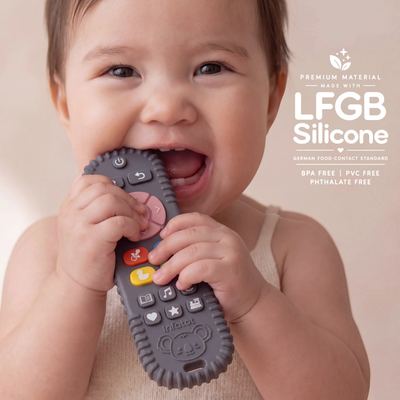 Baby chewing the remote-shaped teether from the Plum Koda Koala pair