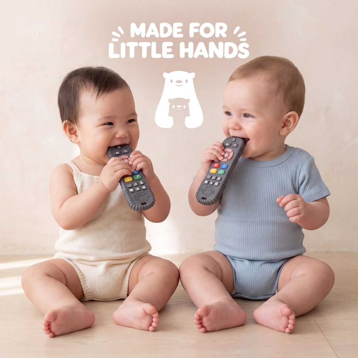 Two seated babies holding Infatot remote-shaped teethers