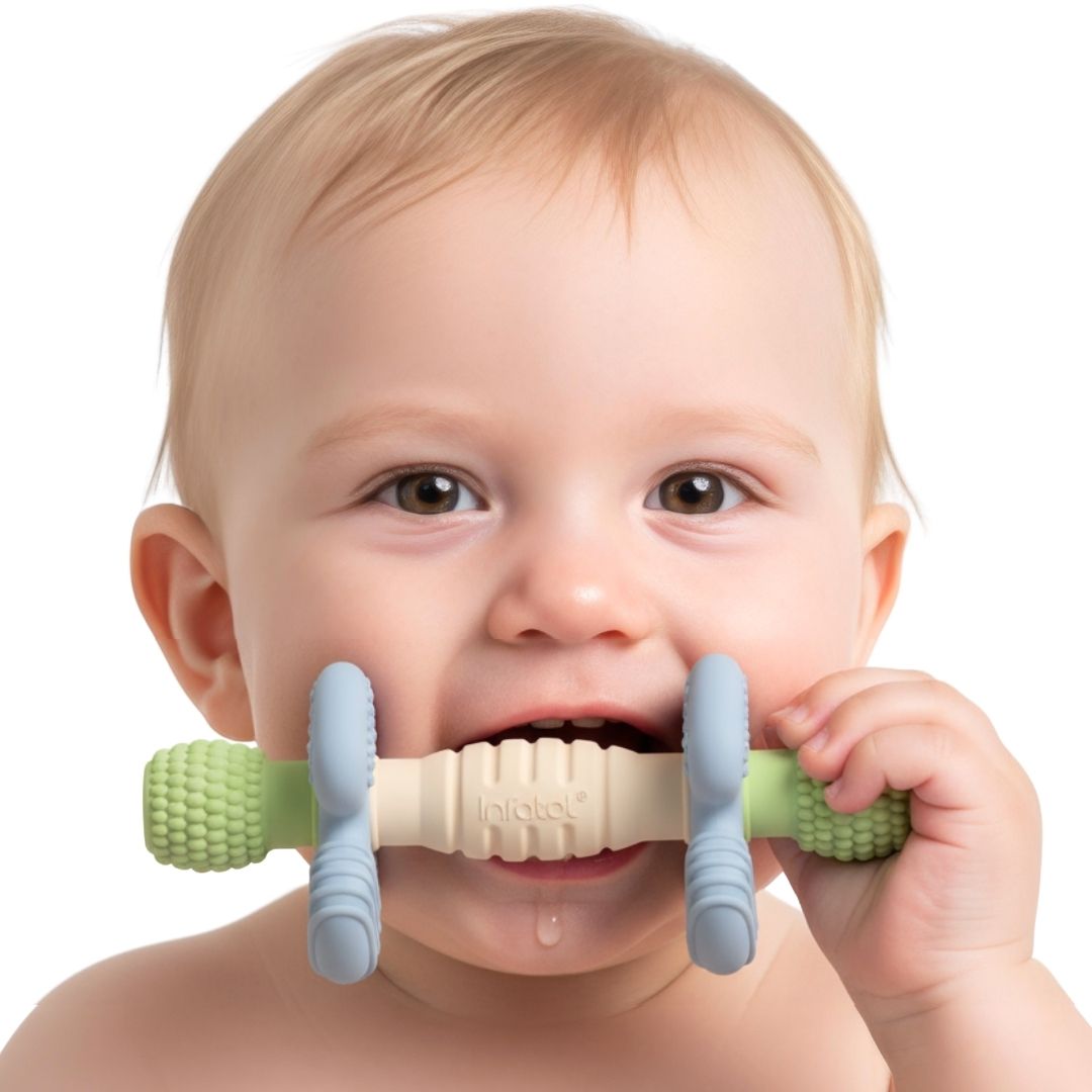 Baby chewing the green, blue and cream Sage Barbell Buddy teether