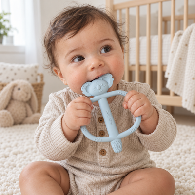 Baby holding and chewing a blue Koda Koala Bitey teether