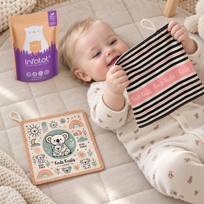Baby lying on a blanket and holding a Blush Koda Koala crinkle sheet