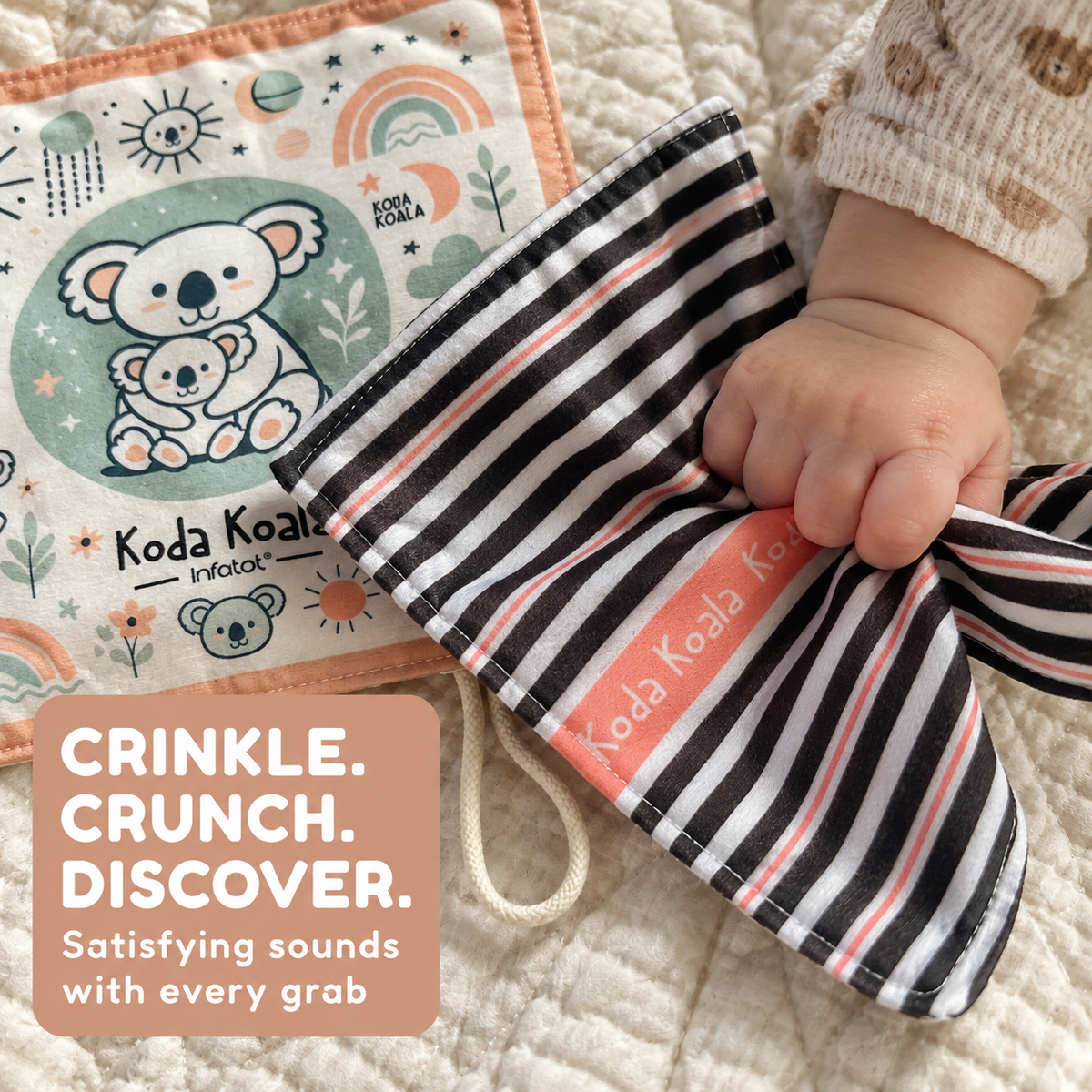 Baby's hand scrunching the striped side of a Koda Koala crinkle sheet